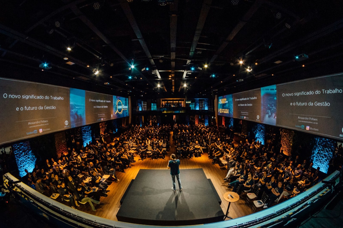 A speaker addresses a large audience in a conference hall