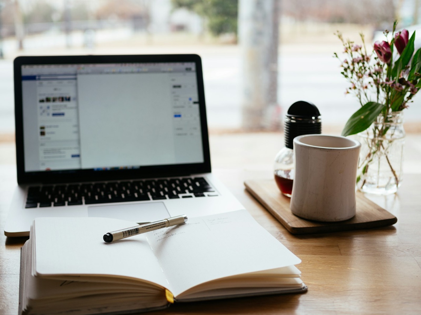 A laptop and an open notebook on a desk, ready for a learning session